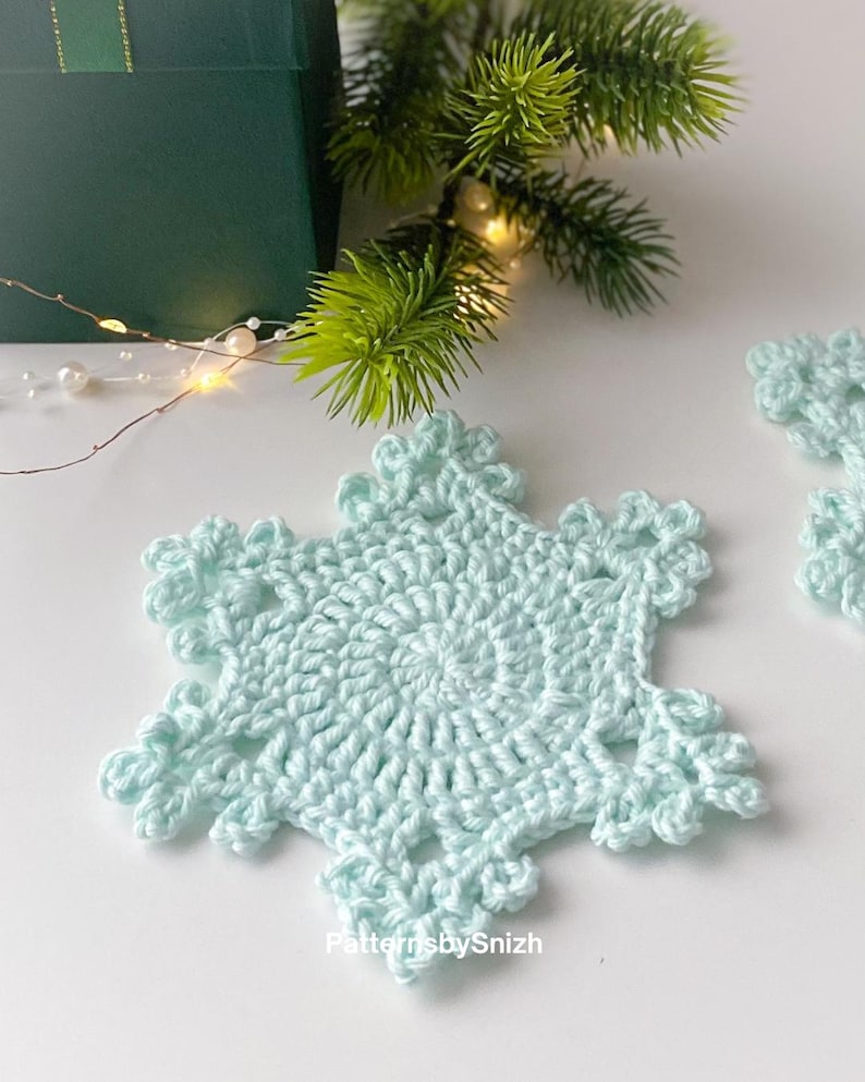 Crochet snowflake coaster made with cotton yarn, perfect as a Christmas table decoration, tea or coffee cup mat, or handmade gift. Digital crochet pattern PDF for beginners and intermediate crocheters.