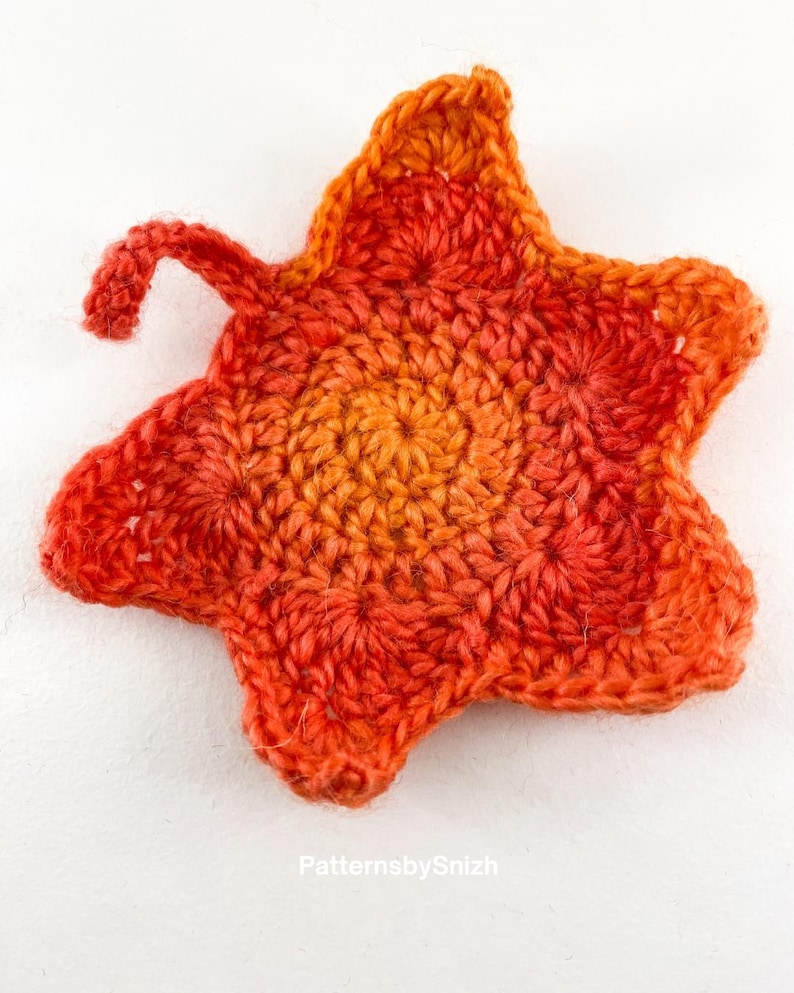 Large crochet maple leaf coaster made with ombré autumn yarn. Handmade fall home décor perfect for table settings, seasonal decorations, or as a unique crochet gift