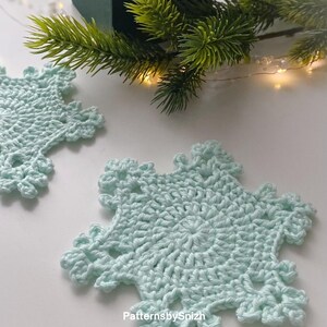 Crochet snowflake coaster made with cotton yarn, perfect as a Christmas table decoration, tea or coffee cup mat, or handmade gift. Digital crochet pattern PDF for beginners and intermediate crocheters.