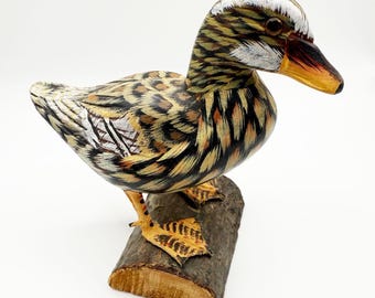 Hand-carved and painted wooden duck figurine on natural wood base