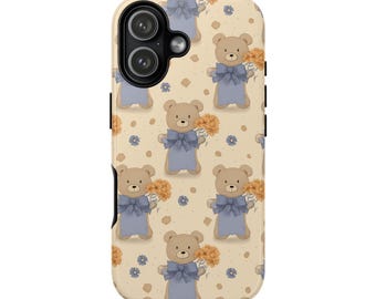 May include: A beige phone case featuring a repeating pattern of cartoon teddy bears wearing blue bows and holding bouquets of orange flowers. The case has a black camera lens and buttons on the side.