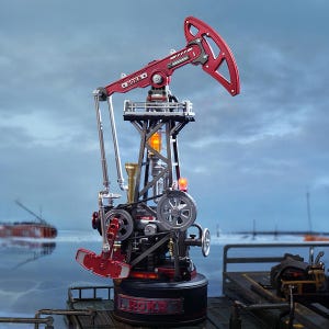 May include: A detailed model oil pump jack, predominantly red and black. The model features intricate mechanical details, including a rocking arm, gears, and a tower structure. The base is black with the text "ROKR".