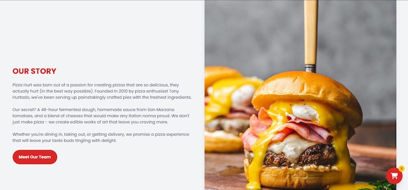 May include: A close-up of a gourmet burger with a golden bun, melted cheese, ham, and a yellow sauce. A knife is inserted through the top bun. The burger is on a wooden surface.