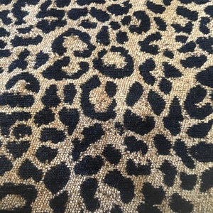 May include: Close-up of a brown and black fabric with a leopard print pattern.