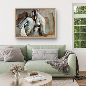 May include: Abstract painting in a wooden frame. The artwork features a blend of white, brown, and teal brushstrokes. The painting hangs above a green sofa with gray pillows and a round coffee table.