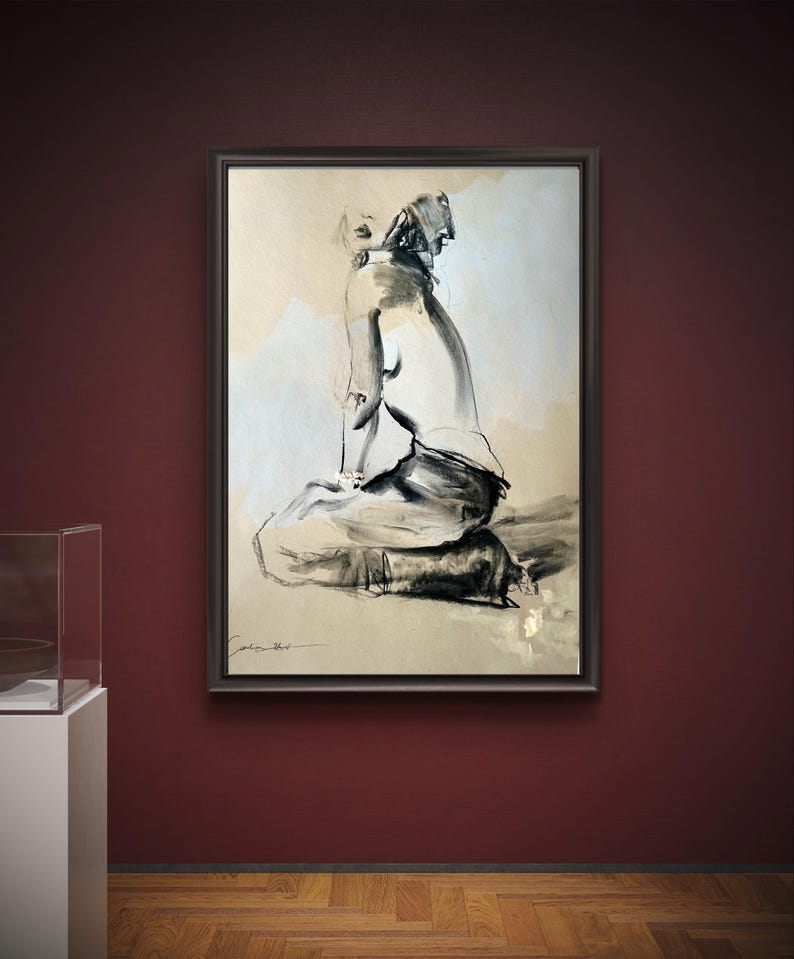 May include: A framed black and white artwork depicting a seated figure in a minimalist style. The artwork is displayed on a dark red wall, with a wooden floor visible below. The figure is rendered with bold brushstrokes, creating a sense of movement and emotion.