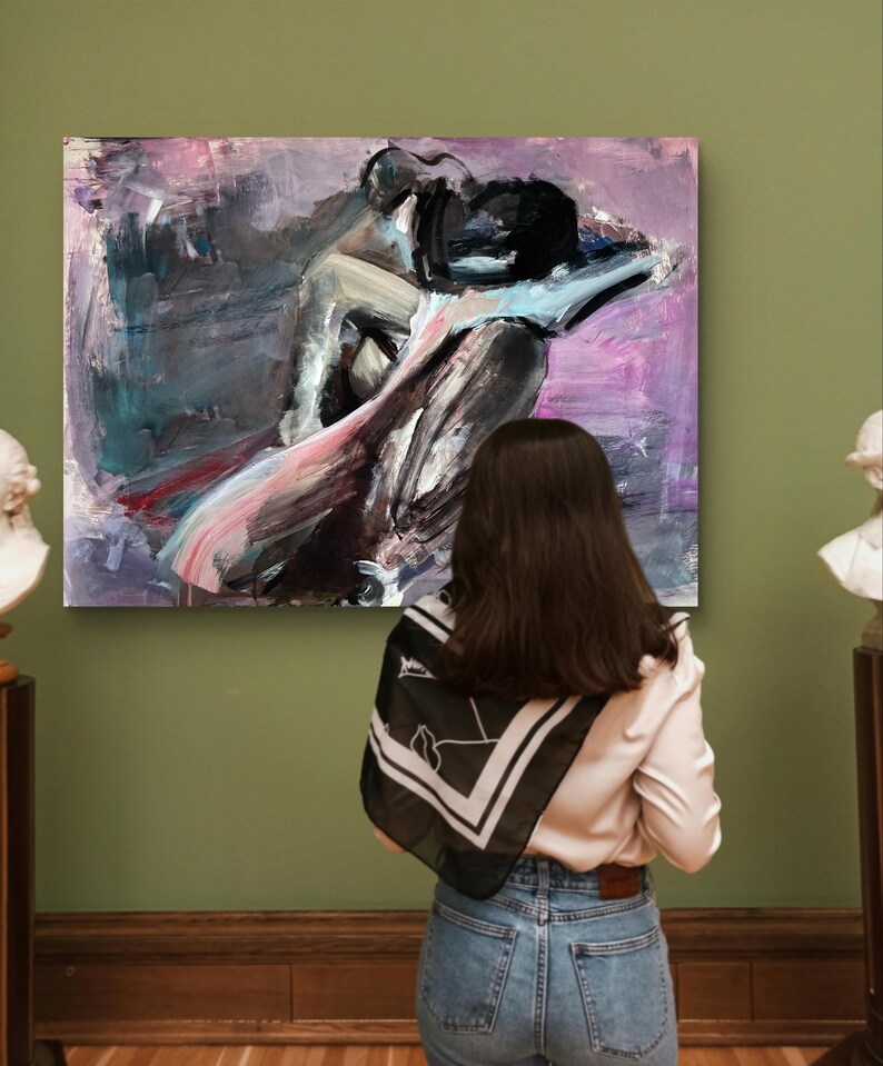 May include: An abstract painting of a couple embracing, in black, grey, pink, and purple hues. The artwork is displayed on a green wall, viewed by a person wearing a white shirt, blue jeans, and a black and white scarf.