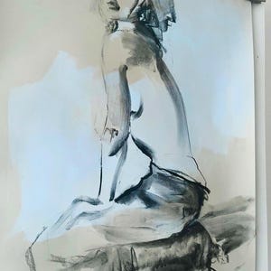 May include: A charcoal drawing of a seated figure, rendered in shades of gray and black on a light beige background. The artwork depicts a person in a seated pose, with a focus on the form and shadows, creating a sense of depth and texture.