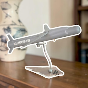 May include: A set of three ceramic mugs with a speckled, matte finish in cream, light grey, and dark grey. Each mug has a simple, minimalist design and a rounded handle.