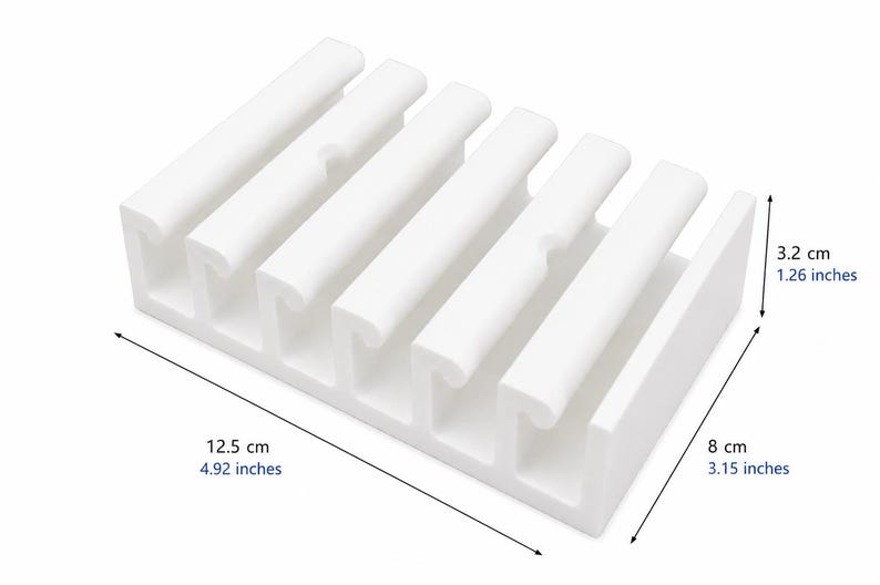 May include: A white rectangular cable organizer with five parallel slots for cord management. The unit measures 4.92 inches in length, 3.15 inches in width, and 1.26 inches in height, featuring a structured design to hold multiple cables securely in place.