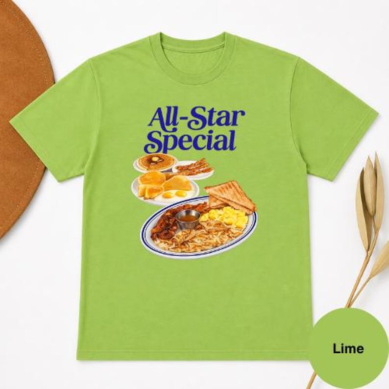 May include: Lime green t-shirt with the words "All-Star Special" in blue. The graphic depicts a breakfast plate with eggs, bacon, toast, and hash browns. A small circle at the bottom right says "Lime".