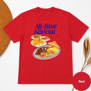May include: Red t-shirt with the text "All-Star Special" in blue. The graphic features a plate of breakfast food, including pancakes, eggs, bacon, toast, and hash browns. A red circle with the word "Red" is in the bottom right corner.