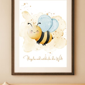 Könnte beinhalten: Gerahmter Aquarelldruck mit einer lächelnden Cartoon-Biene mit gelben und schwarzen Streifen, blauen Flügeln und einem hellbraunen Hintergrund. Der Text "Flieg los und entdecke die Welt" ist in goldener Schrift geschrieben. Das Kunstwerk ist in einem dunkelbraunen Rahmen.
