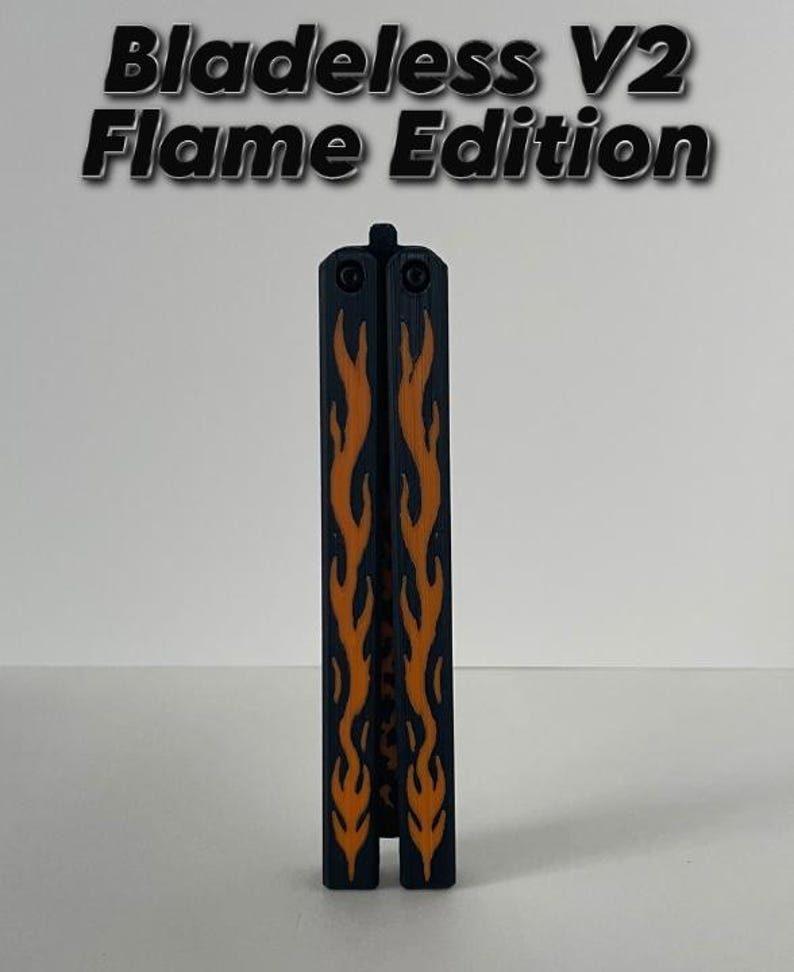 May include: A black and orange Bladeless V2 Flame Edition butterfly knife trainer. The closed tool features a dark handle with a prominent orange flame pattern running vertically along the center. The text Bladeless V2 Flame Edition is visible.