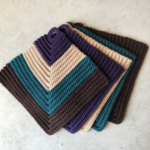 May include: Set of four crocheted pot holders in brown, teal, purple, and beige. The pot holders are layered on top of each other, with the brown one on the bottom and the beige one on top.