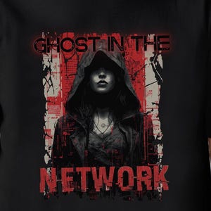 May include: Black t-shirt featuring a graphic of a person in a hooded jacket with the text "GHOST IN THE NETWORK" in red. The design has a distressed, grunge aesthetic.