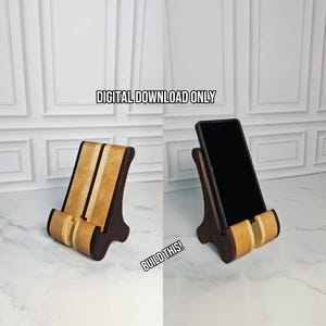 May include: A two-tone wooden phone stand featuring a light-colored wood center and dark-colored wood sides. The image includes the text "DIGITAL DOWNLOAD ONLY" and "BUILD THIS!" and shows the stand empty and holding a black smartphone.