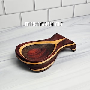 May include: A wooden spoon rest featuring a teardrop shape with alternating dark reddish-brown and light tan wood grain layers. The text "DIGITAL DOWNLOAD ONLY" is printed above the object. The spoon rest has a curved handle and a deep bowl.