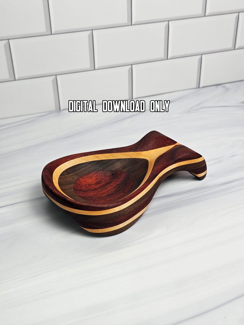 May include: A wooden spoon rest featuring a teardrop shape with alternating dark reddish-brown and light tan wood grain layers. The text "DIGITAL DOWNLOAD ONLY" is printed above the object. The spoon rest has a curved handle and a deep bowl.