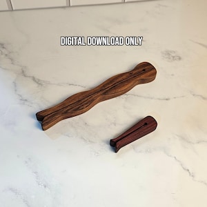 Puede incluir: Dos objetos de madera de color marrón oscuro con forma de pinza de ropa y vetas visibles. El objeto más grande es alargado y ondulado, mientras que el más pequeño es corto y recto. El texto DIGITAL DOWNLOAD ONLY aparece sobre los objetos.