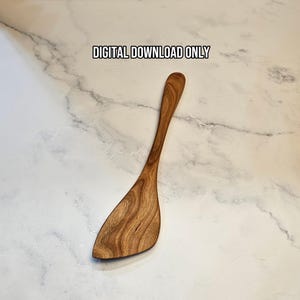 May include: A wooden spatula with a distinct grain pattern and a wide, angled head. The text DIGITAL DOWNLOAD ONLY is printed above the spatula. The object is shown from a top-down perspective, highlighting the natural brown tones of the wood.