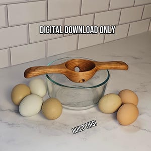 May include: A wooden egg separator with two handles resting on a clear glass bowl, surrounded by several brown and white eggs. The text DIGITAL DOWNLOAD ONLY and BUILD THIS! is visible. The separator features a central circular opening for eggs.
