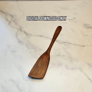 Könnte beinhalten: Ein dunkelbrauner Holzspatel mit langem Griff und einer breiten, flachen Klinge mit sichtbarer Holzmaserung. Der Text DIGITAL DOWNLOAD ONLY ist in Schwarz über dem Spatel aufgedruckt und weist auf ein digitales Produkt hin.