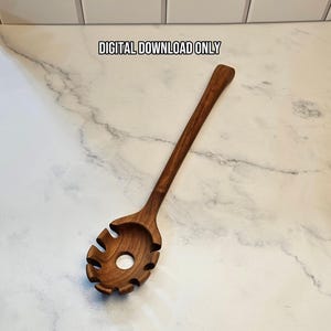 May include: A dark brown wooden pasta server with a long handle and a slotted head featuring a central hole. The text DIGITAL DOWNLOAD ONLY is printed above the utensil. The item is displayed against a white marble surface with gray veining.