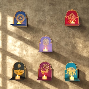 May include: Six wall-mounted arched shelves in blue, red, purple, black, magenta, and teal, each featuring a gold-coloured cutout design including an Om symbol, Ganesha, lotus, diya lamp, peacock, and elephant, with a lit tea light candle on each.