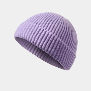 May include: A lilac-colored ribbed knit beanie hat. The hat is made of a soft, textured material and features a folded brim. The beanie is a solid color and is suitable for cold weather.