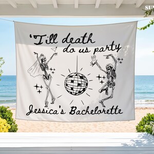 May include: A white rectangular fabric banner featuring black line art of two skeletons dancing around a disco ball. The text reads 'Till death do us party' at the top and 'Jessica's Bachelorette' at the bottom, with small star accents.