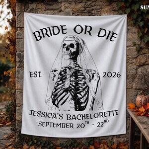 May include: A white rectangular fabric banner featuring a black graphic of a skeleton wearing a bridal veil. The text reads BRIDE OR DIE, EST. 2026, JESSICA'S BACHELORETTE, and SEPTEMBER 20TH - 22ND in a black serif font centered on the fabric surface.