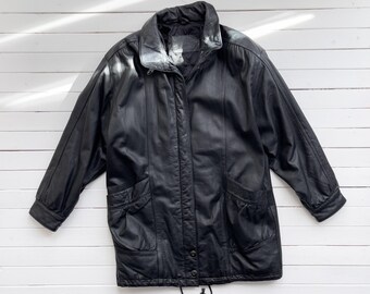 Könnte beinhalten: Eine schwarze Lederjacke mit Reißverschluss, zwei Taschen vorne und einem Kordelzug unten.