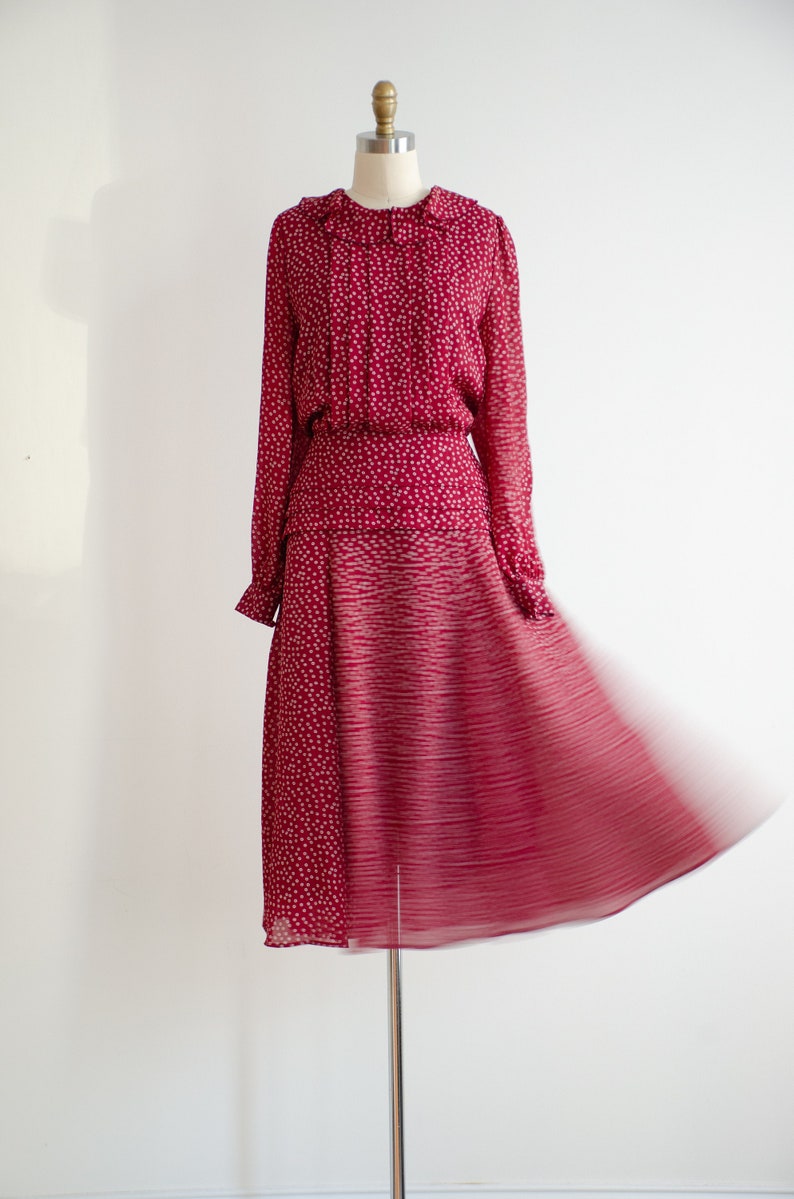 May include: A red dress with a white polka dot pattern and a ruffled collar. The skirt is a-line and has a gradient pattern.