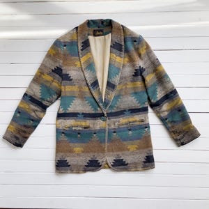 May include: A brown, blue, and yellow patterned blazer with a single button closure. The blazer has a notched collar and a  "J.Crew" label on the inside.