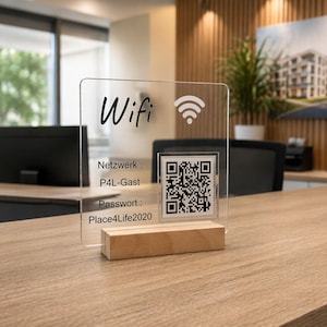 May include: A clear acrylic sign with a wooden base featuring the text Wifi, a signal icon, and a QR code. The sign displays the text Netzwerk : P4L-Gast and Passwort : Place4Life2020 in black lettering, providing information for wireless internet access.