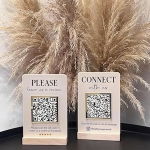 May include: Two cream-colored table signs with wooden bases. One sign reads "PLEASE leave us a review" and the other says "CONNECT with us." Each sign has a QR code and instructions to scan for a review or to visit a homepage.