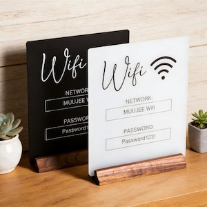May include: Two rectangular signs with wooden bases. One sign is black with white text, the other is white with black text. Both feature the word Wifi, a signal icon, and fields labelled Network and Password with the text MUUJEE Wifi and Password123!.