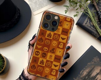 May include: A Halloween-themed phone case featuring a repeating pattern of orange and brown squares with spooky icons like pumpkins, bats, ghosts, and spiders. The case is held against a neutral background.
