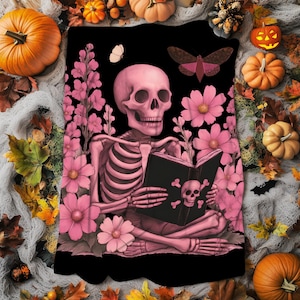 May include: A pink skeleton reading a book with a skull and crossbones on the cover, surrounded by pink flowers and butterflies, set against a black background. The image has a Halloween theme with pumpkins and autumn leaves.