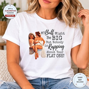 May include: A white short-sleeved t-shirt featuring a graphic of a pin-up style illustration of a person sitting on a stool in front of a mirror, with the text: MY Butt Might Be BIG But Nobody is Rapping About Your FLAT ONE!
