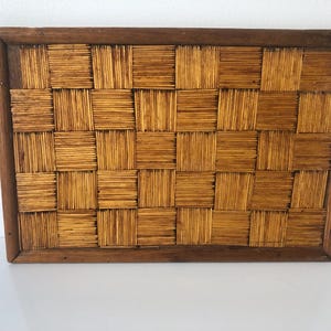 Peut inclure: Une pièce d'art mural rectangulaire présentant un motif en mosaïque de fines allumettes en bois brun clair disposées en blocs alternés horizontaux et verticaux, le tout encadré par un cadre en bois brun foncé aux coins biseautés.