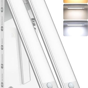 May include: Two slim, rectangular silver LED under-cabinet lights with motion sensors and integrated control buttons. The packaging box displays icons for dimmable, motion sensor, magnetic, rechargeable, and high quality features, plus a 2-pack label.