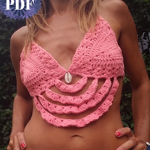 May include: A pink crochet halter top with a seashell detail. The top has a scalloped design along the lower edge. The text "PDF" is in the upper left corner, and "UknitMe2" is at the bottom.