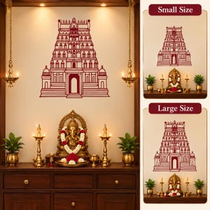 Può includere: Un adesivo da parete rosso scuro con un'illustrazione a linee dettagliata di un gopuram di un tempio tradizionale. Il design è mostrato sopra un altare in legno con una statua di Ganesha in ottone, due lampade a olio e due piante verdi.