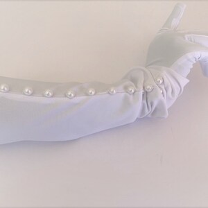 May include: White long opera gloves with pearl embellishments along the cuff.