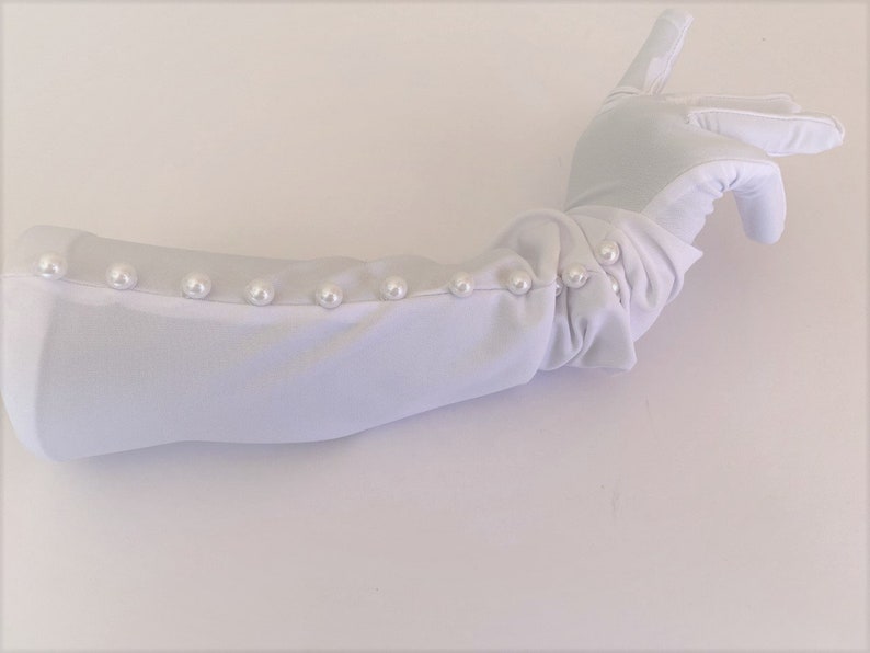 May include: White long opera gloves with pearl embellishments along the cuff.