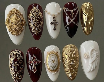 Uñas postizas 3D doradas artísticas estilo stiletto hechas a mano, uñas postizas rojas oscuras con cruz y un intrincado diseño barroco de lujo.