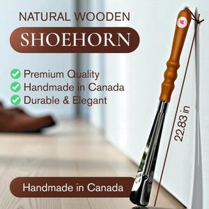 May include: A natural wooden shoehorn with a polished metal blade. The handle is made of light brown wood and features a small red maple leaf emblem. The shoehorn measures 58 cm in length.