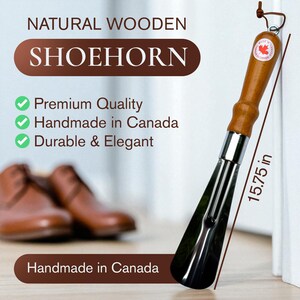May include: A natural wooden shoehorn, approximately 40 cm long, with a polished metal blade and a wooden handle. The handle has a leather loop and a small emblem. Text on the image reads "Handmade in Canada".